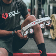 ROLL Recovery R8 アルパインホワイト ふくらはぎを挟み込みトレーニング後にセルフケアする様子を斜め前方から捉えたモビリティーツール