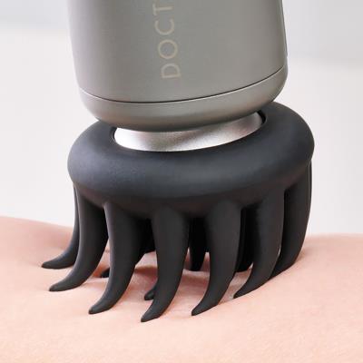 DOCTORAIR エクサガンLUXE ブラックのブラシ型アタッチメントを身体に当てた使用例。複数の突起が肌に接触する状態を確認できる構成