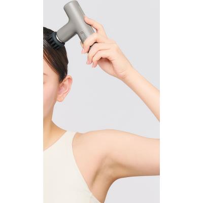 DOCTORAIR エクサガンLUXE ブラックを頭部に当てた使用例。ブラシ型アタッチメントを装着し、頭皮へ当てながら使用する状態を確認できる構成