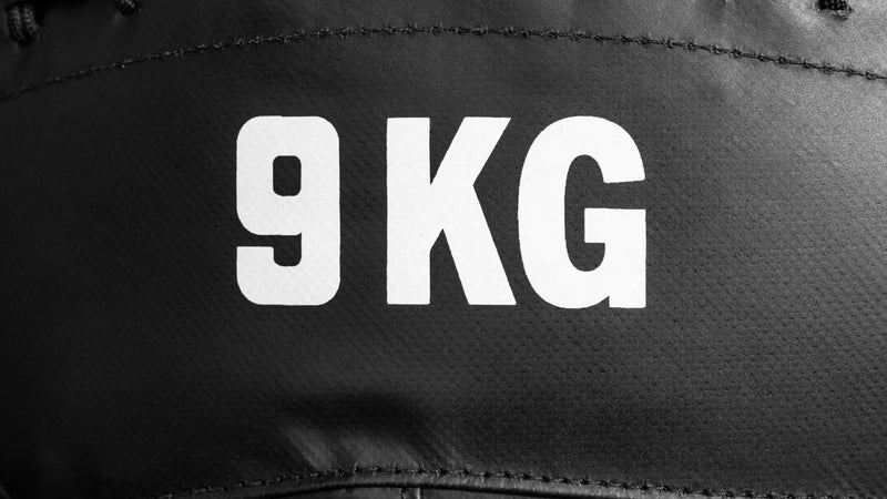 ROGUE KG メディシンボール ブラック ウォールボールスクワット動作で胸元に保持した使用シーン。コンディショニングトレーニングに最適