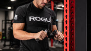 シルバーのROGUE Vグリップ ケーブルアタッチメントを使用し、ケーブルカールを行う手元を正面から捉えたグリップポジション