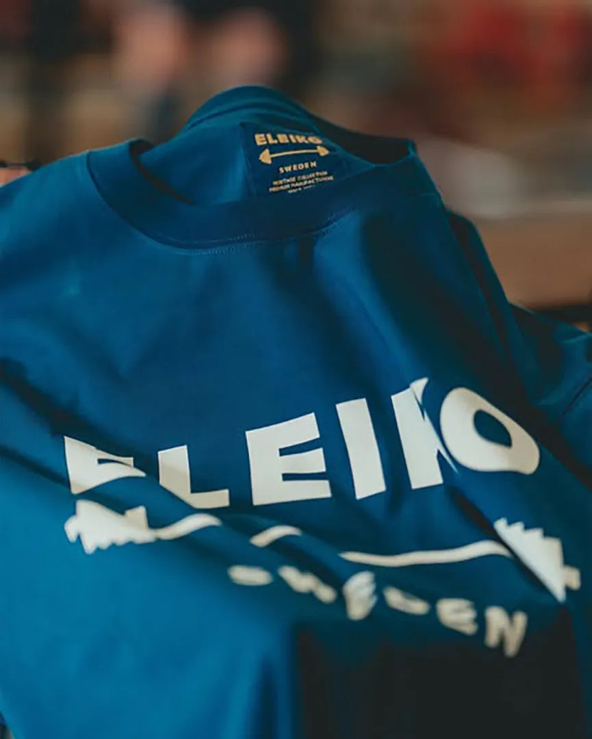 ボルドーカラーのELEIKOパーカーを斜め上から写したアパレルディテール。胸元にELEIKOロゴとバーベルデザイン、SWEDENの文字をプリント。